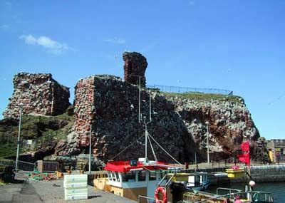 a boat docked in front of a large rock formation