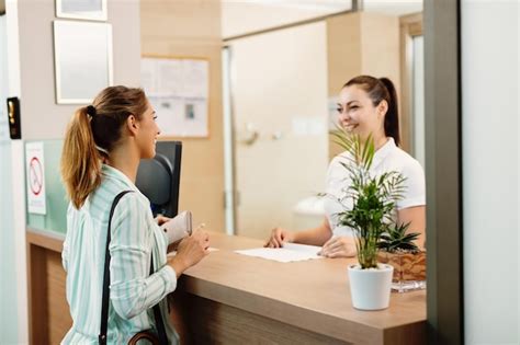 Free Photo | Happy woman talking to a receptionist while arriving at ...