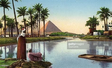 Two local Egyptian men sitting by the Nile River, looking at the ...