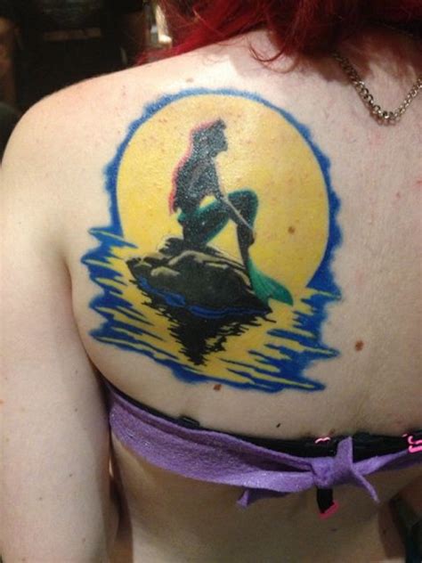 Very beautiful colored cartoon mermaid sitting on rock back tattoo with ...