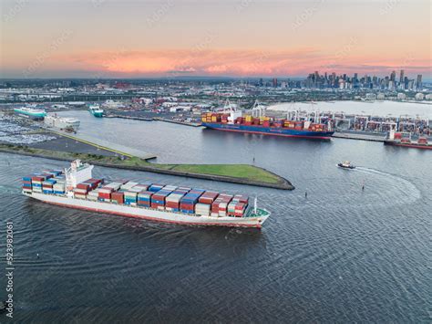 Aerial view of a cargo ship leaving port fully laden with containers ...