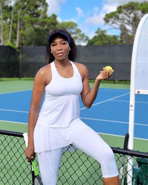 a woman holding a tennis ball and racket