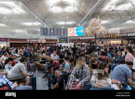 LONDON - AUGUST 7, 2019: Crowd of people at busy airport terminal at ...