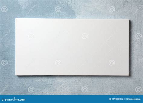 Blank Canvas Hanging on Light Blue Wall, Space for Text Stock Photo ...