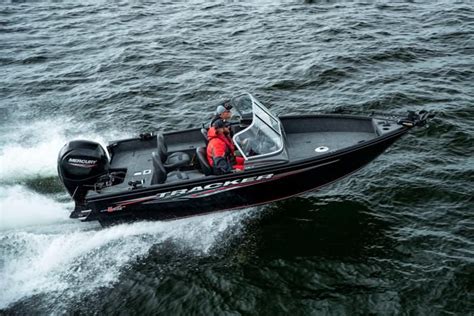 a man riding on the back of a black and red boat in the middle of water