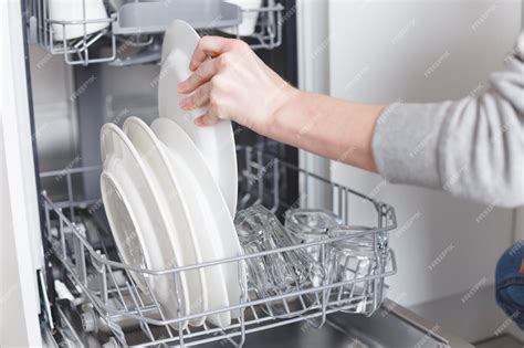 Premium Photo | Housework: young woman putting dishes in the dishwasher