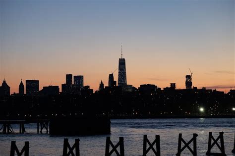 Premium Photo | Silhouette skyline during sunset seen from river