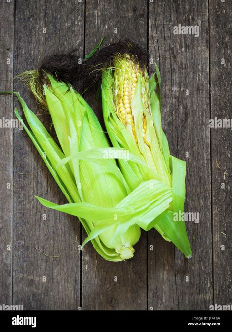 A corn cob on aold retro wooden table Stock Photo - Alamy