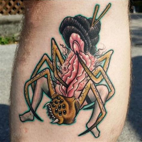 a close up of a person's leg with a tattoo on it and a large spider