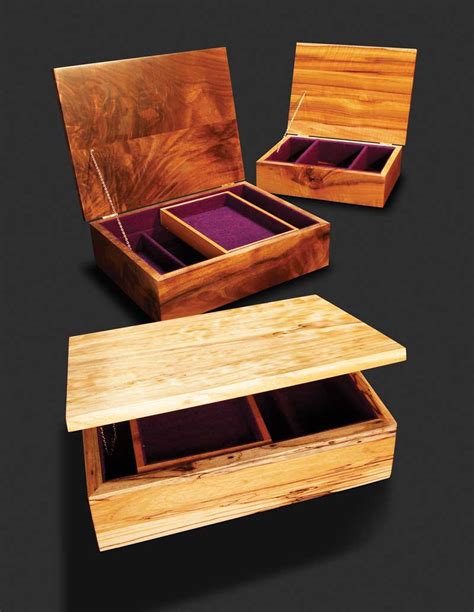 three wooden boxes with purple velvet inside and outside the lids, one ...