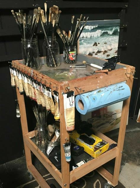 an artist's easel filled with paint and brushes