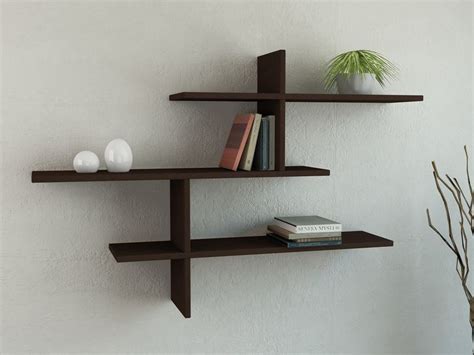 three shelves with books and vases on them against a wall in a living room