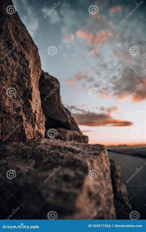 A Rocky Cliff at Sunset with the Sun Setting on the Ocean in the ...