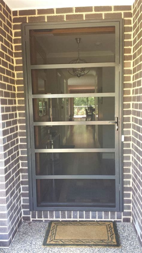 an open door to a brick building with a welcome mat on the ground below it