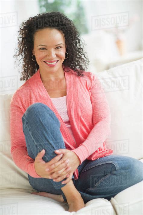 Portrait of woman sitting on sofa - Stock Photo - Dissolve