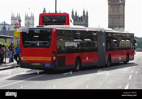 A bendy bus traveling around a double decker bus on Westminster Bridge ...