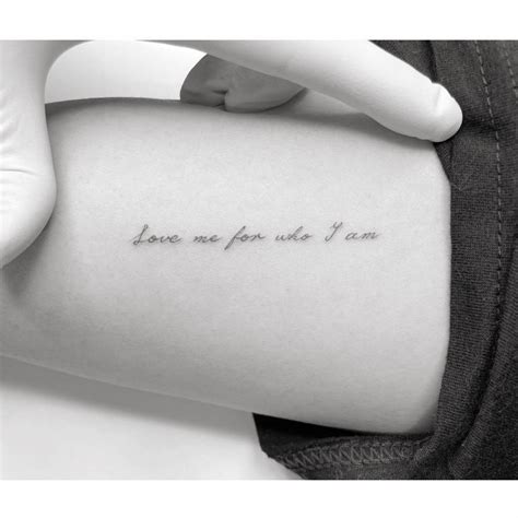 "Love me for who I am" lettering tattoo located on the