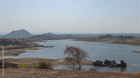 Landscape of Jawai dam with water, clear blue sky and Aravalli mountain ...