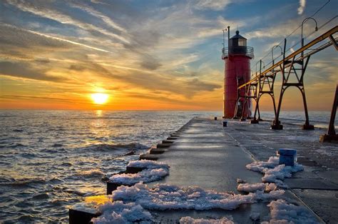 Sunset on snowy boardwalk to lighthouse. Van Buren County, Michigan ...