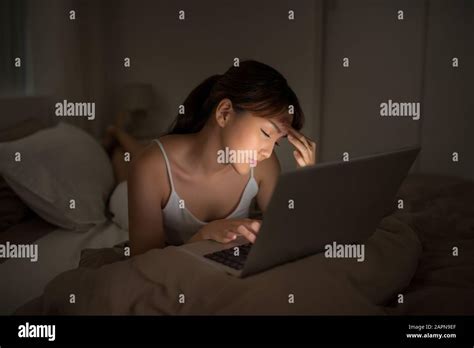 Bedroom evening - woman with laptop lying down in bed Stock Photo - Alamy