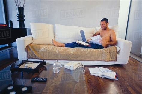 Man studying with laptop in living room - Stock Photo - Dissolve