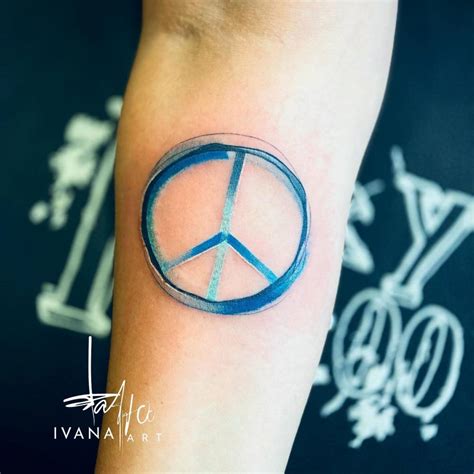 Peace symbol tattoo located on the inner forearm,