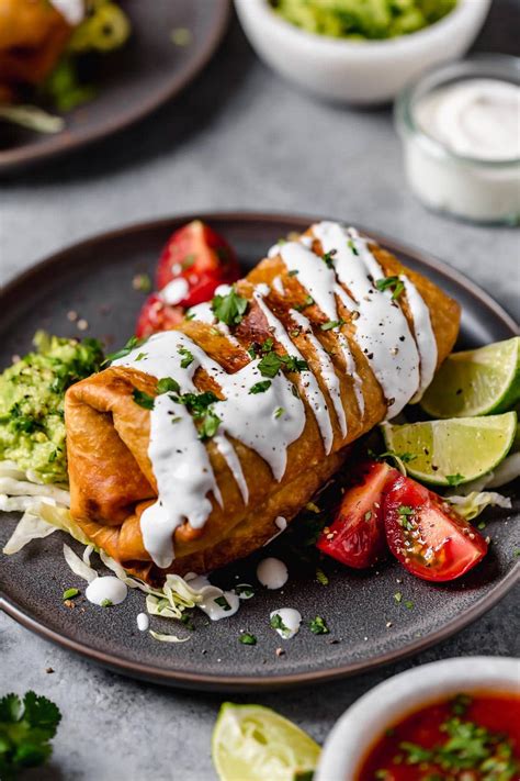 Chicken Chimichanga on a plate. It's drizzled with sour cream ...