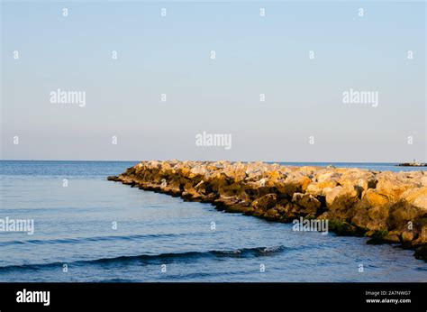 Stones wave breaker and sea against sunset blue sky during summer Stock ...