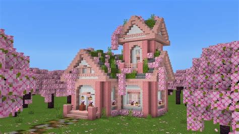 a large pink house surrounded by trees and flowers