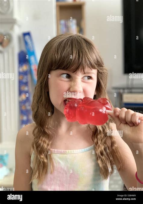 Girl Eating Giant Gummy Bear Sweet Stock Photo - Alamy