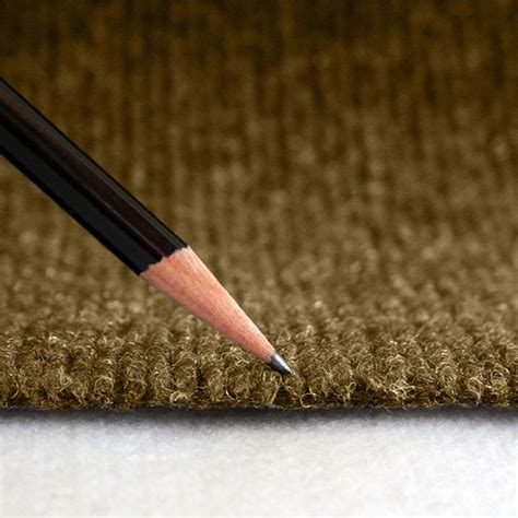 a pencil that is laying on the ground next to a rug with a brown background