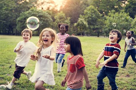 Group of Diverse Kids Playing at the Field Together - Yvonne Miller