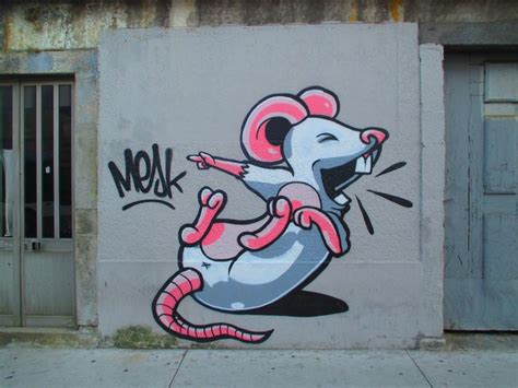 graffiti on the side of a building depicting a rat with its mouth open ...