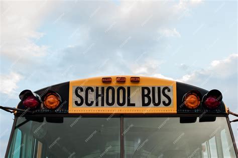 Premium Photo | Front top view of a yellow school bus on a sky with clouds