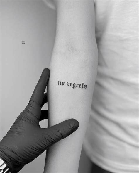 "No regrets" lettreing tattoo in gothic font, located