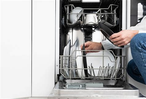 Premium Photo | Woman doing dishes in dishwasher at home