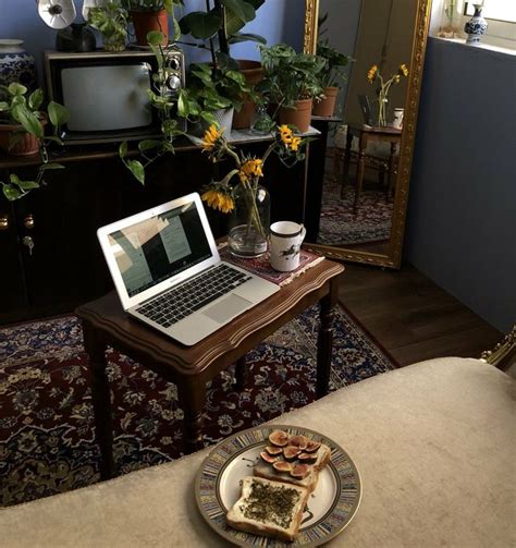 a laptop computer sitting on top of a wooden table next to a plate of food