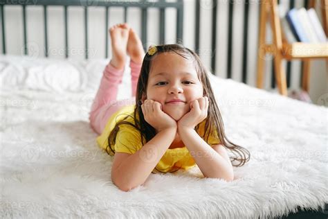 Little girl lying on bed and look at camera. 9814857 Stock Photo at ...