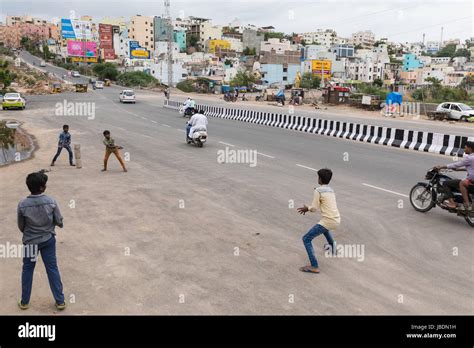 Indian kids playing cricket on a busy street in Hyderabad,India Stock ...