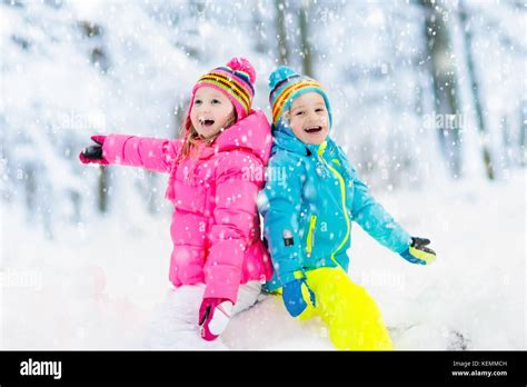 Kids playing in snow. Children play outdoors on snowy winter day. Boy ...