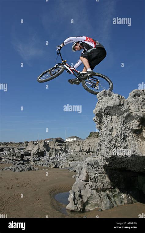 A Mountain Biker perfoms a stunt on some rocks Stock Photo - Alamy