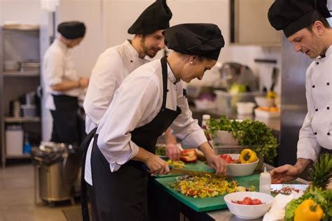 Premium Photo | Professional team cooks and chefs preparing meal at ...