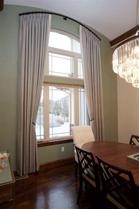 a dinning room table with chairs and a chandelier hanging from the ceiling