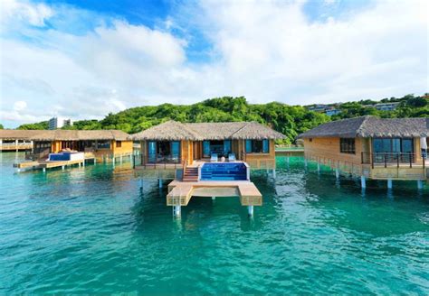 A view of several overwater bungalows in a line each with a private ...