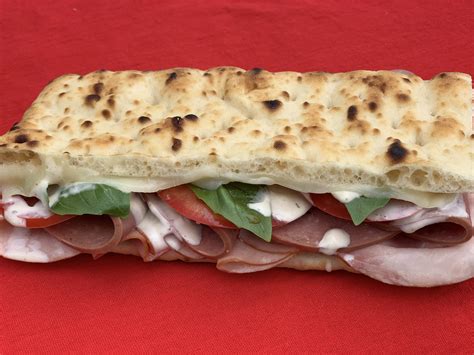 Italian-inspired warm flatbread sandwich with ham, salami, melted ...