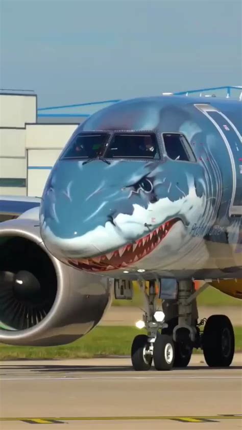 an airplane with a shark face painted on it's side sitting on the tarmac