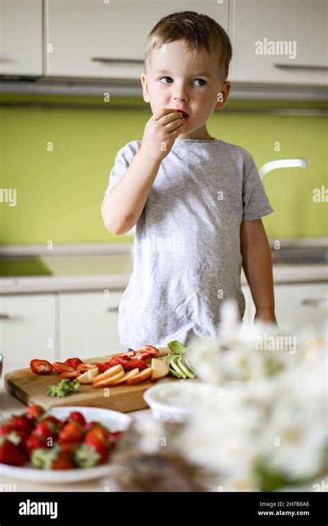 Cheerful boy cooking healthy breakfast at kitchen with avocado, cottage ...