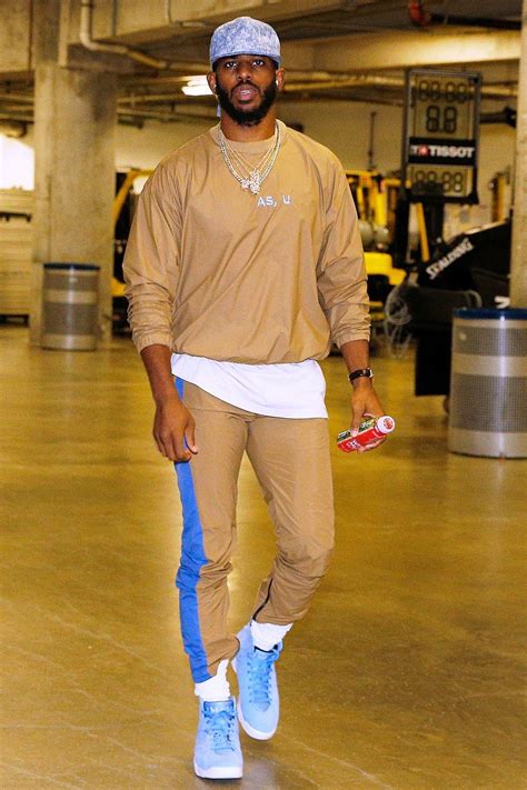 a man in tan shirt and blue pants holding a skateboard