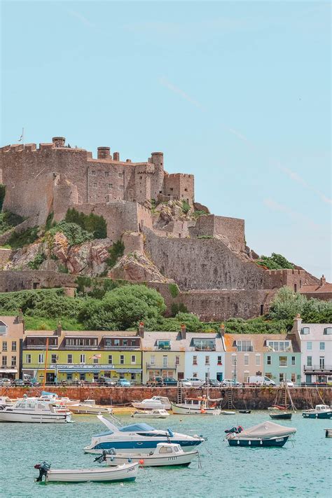 several boats are in the water near a castle on top of a hill that is ...