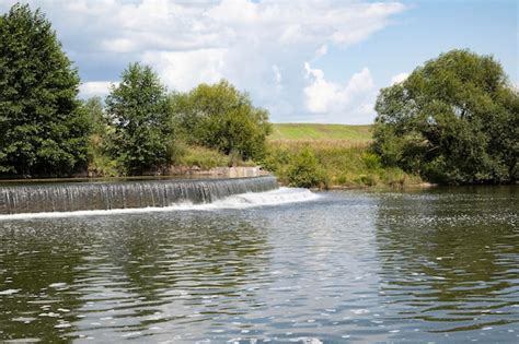 Premium Photo | Waterfall on a pond in a forest in a park in summer on ...